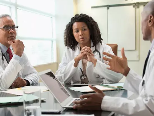 Clinical Ethicist - three scientists sitting around a table talking