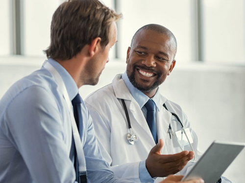 Medical Science Liaison - two men talking. One is a medical doctor and the other is in a dress shirt and tie